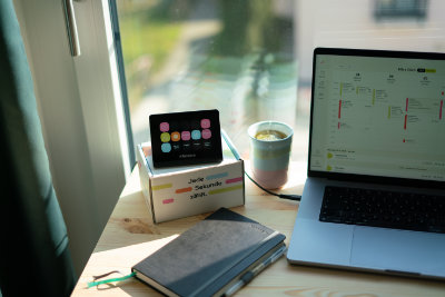 Das Bild zeigt den Einsatz eines timelink Panels auf einem Schreibtisch neber einem MacBook.