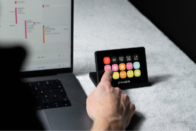 Das Bild zeigt das timelink Panel auf einem Schreibtisch (mit MacBook und anderen Arbeitsutensilien), sowie eine Person die telefoniert.